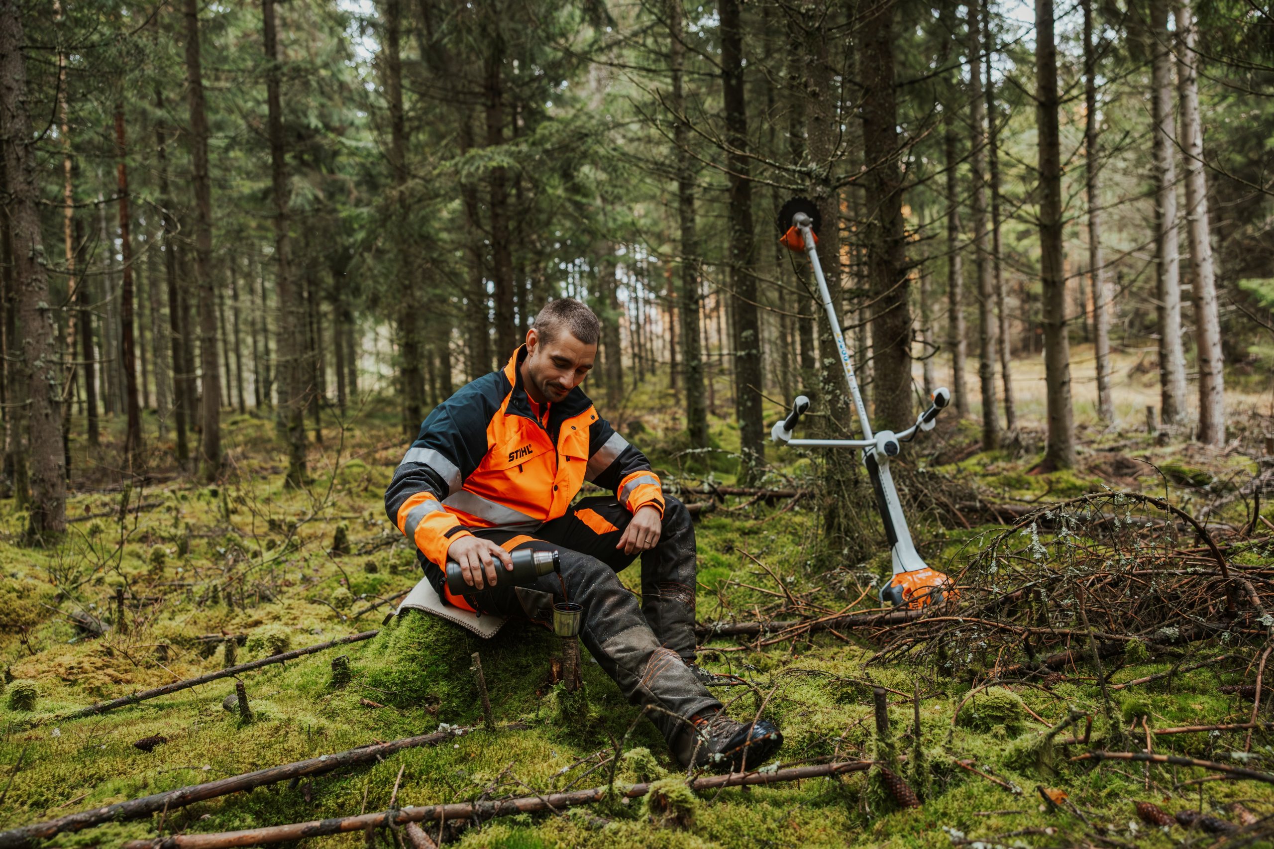 En bild på en person bredvid en röjsåg